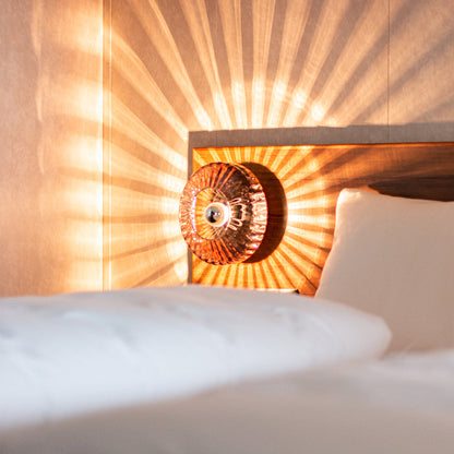 New Wave Optic Wall in Rose hanging as a bedside lamp 